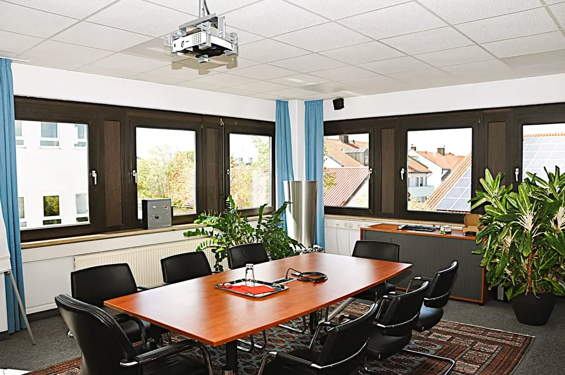 Besprechungsraum im 1. Obergeschoss mit Konferenztisch und Beamer