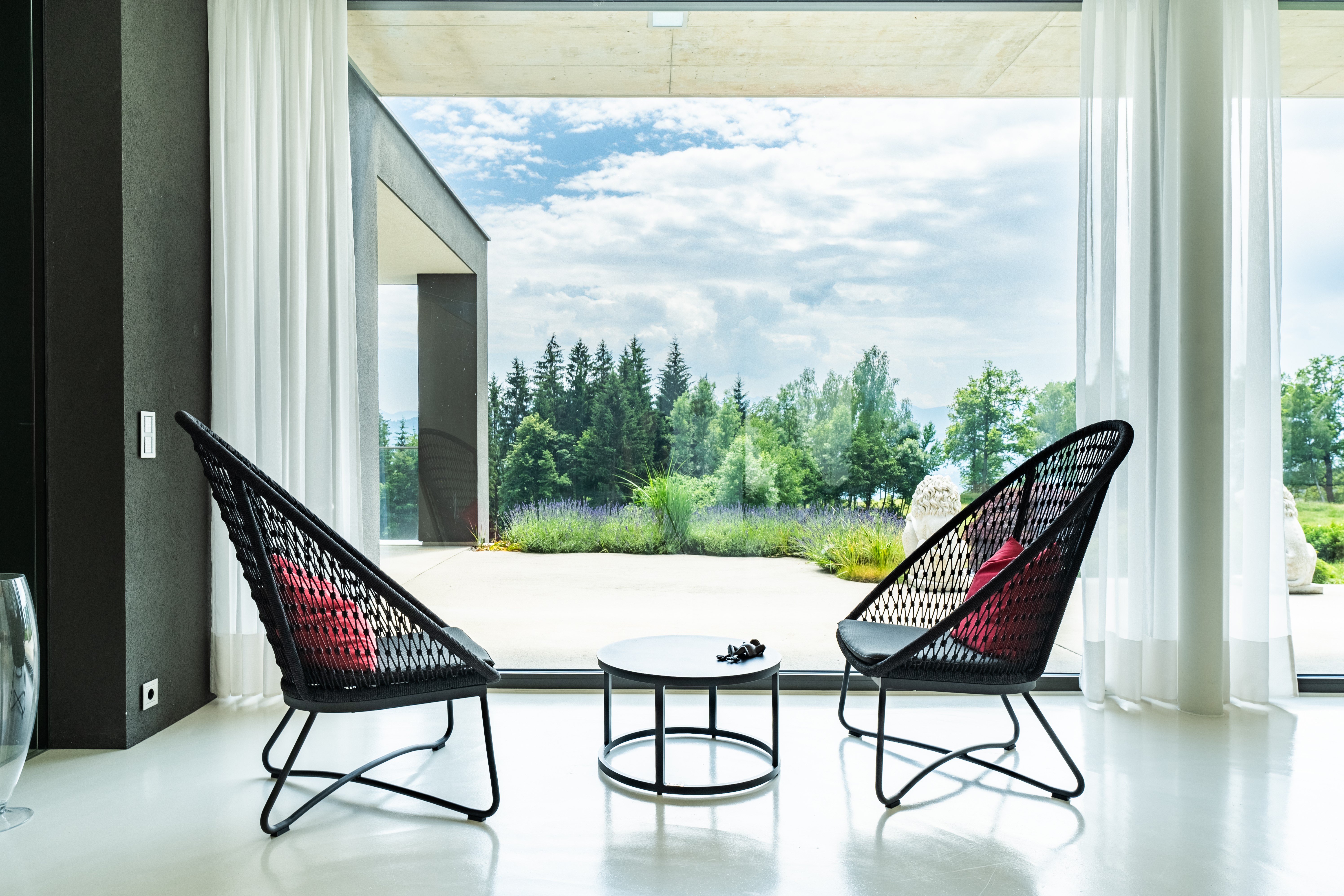 Designsitzplatz mit zwei Loungesesseln und Panoramablick auf den Garten