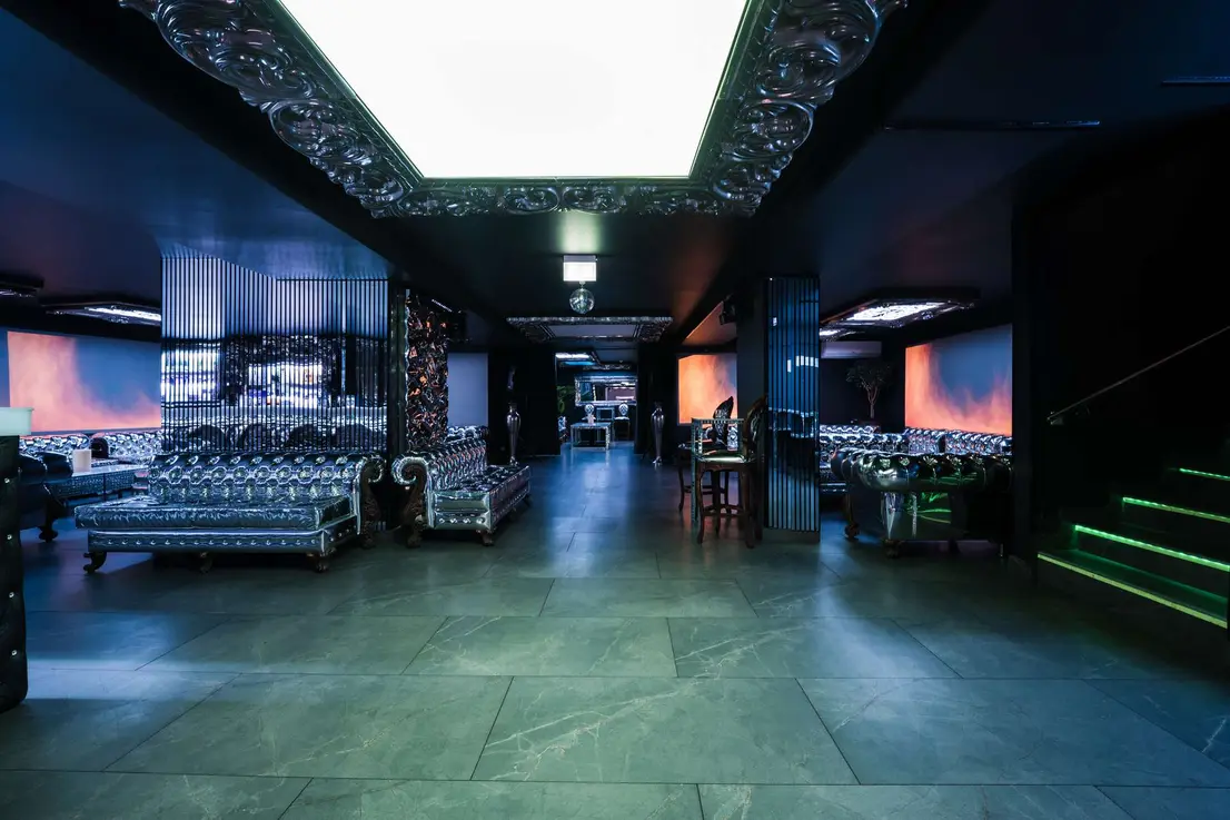 Weitläufiger Veranstaltungsraum mit Lounge-Interieur und markantem Lichtdesign an der Decke