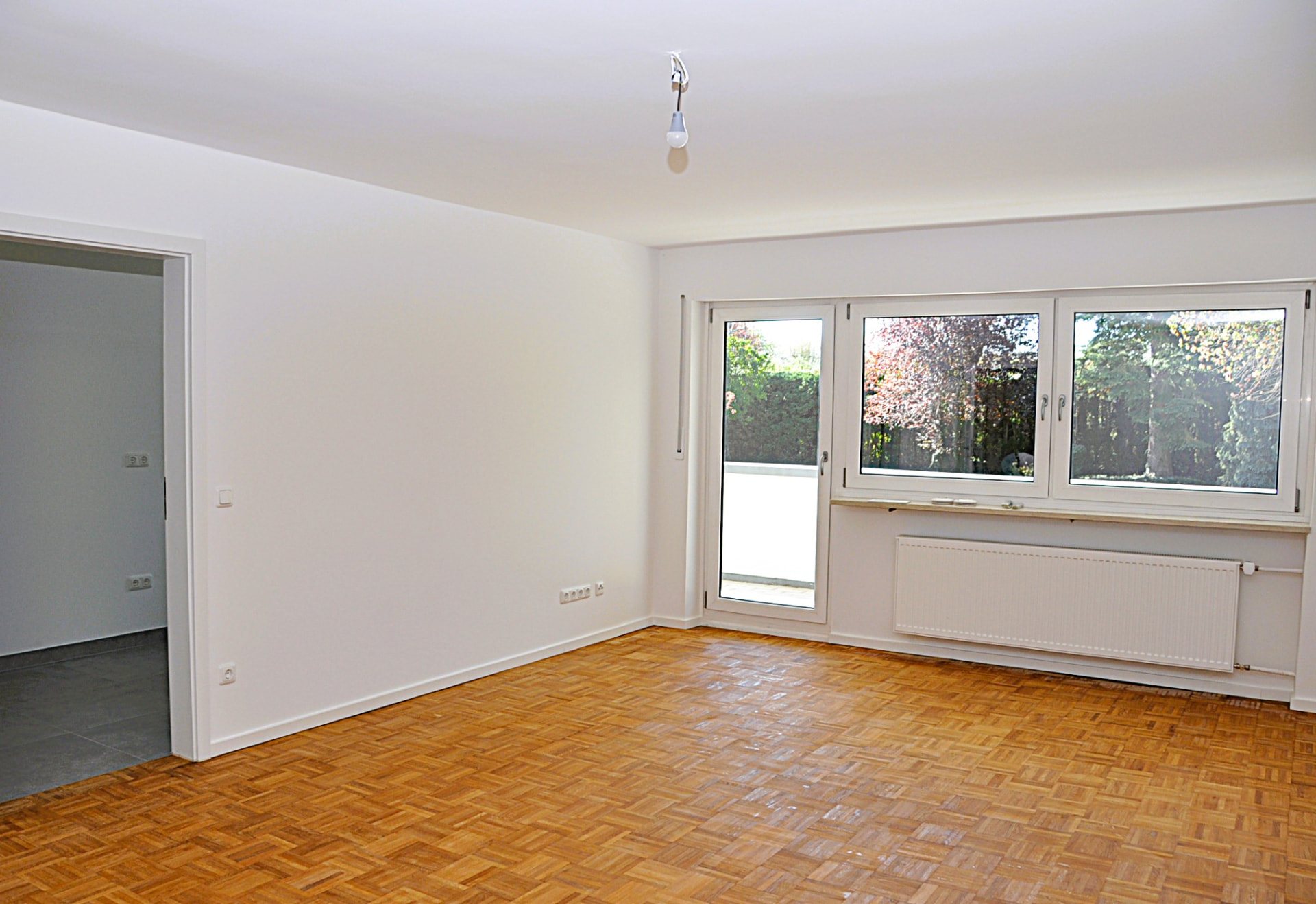 Wohnzimmer mit Fensterfront und Balkontür