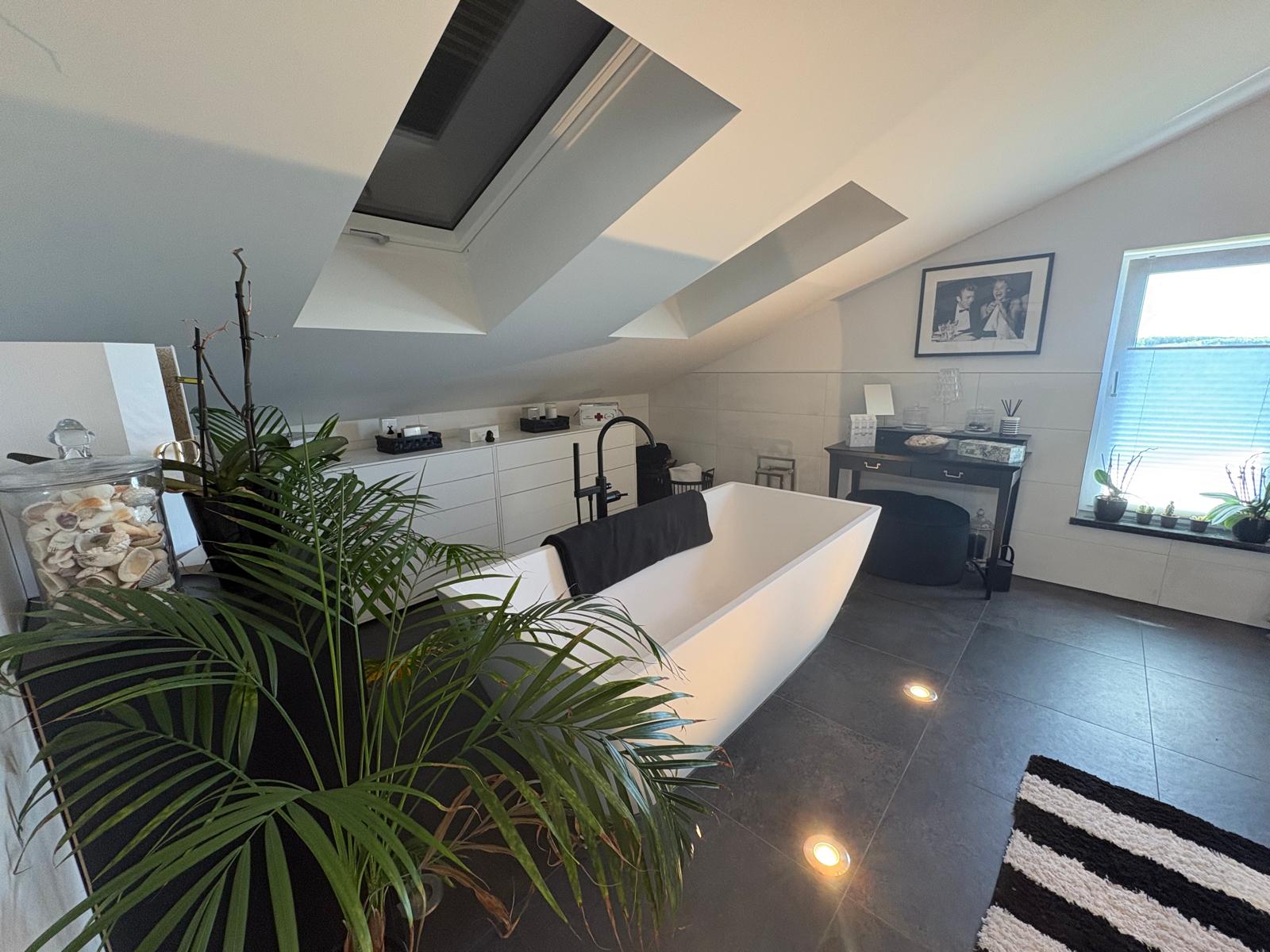 Badezimmer in der Galerie-Ebene mit freistehender Badewanne unter Dachfenstern