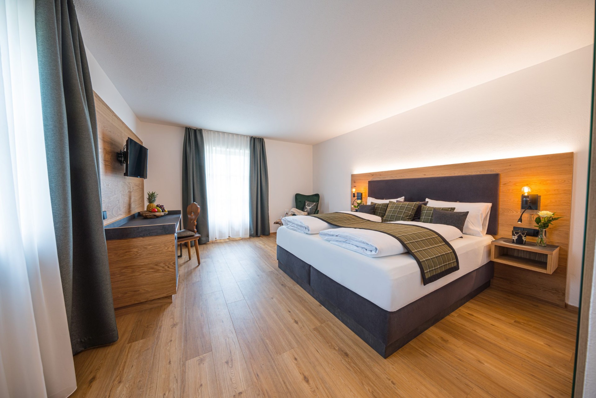 Modern renoviertes Hotelzimmer mit Eichenholz-Bett und Boxspring